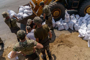 Ukrainian service members pack sandbags for fortification in the Donetsk region, eastern Ukraine, Wednesday, Aug. 3, 2022.