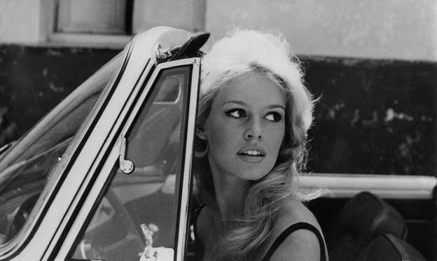 Slide 2 of 31: Brigitte Bardot drives a classic convertible in 1959. 