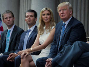 Donald Trump, right, sits with his children, from left, Eric Trump, Donald Trump Jr., and Ivanka Trump during a groundbreaking ceremony for the Trump International Hotel in Washington. Evan Vucci/AP
