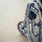 Doente transportada pelos braços para interior de hospital por falta de cadeiras de rodas