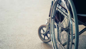 Doente transportada pelos braços para interior de hospital por falta de cadeiras de rodas