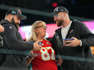 Donna Kelce greets her sons, Jason Kelce and Travis Kelce during Super Bowl Opening Night in Phoenix.