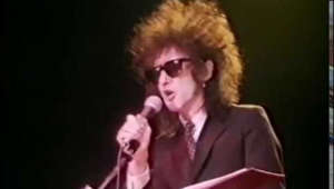 This track, I Wanna Be Yours, is edited from the film, Ten Years In An Open Neck Shirt (© Arts Council of Great Britain, Metropolis Pictures & Channel Four Television Ltd, 1982).

About the poet John Cooper-Clarke, who first attracted attention during the punk movement. Shows him reciting his poems to audiences, talking about his career, discussing the work of earlier poets he admires and working with other new poets including Linton Kwesi Johnson.

Dialogue & Poetry: John Cooper-Clarke

Production Company: Metropolis Pictures Ltd.

© Arts Council of Great Britain, Metropolis Pictures & Channel Four Television Ltd, 1982


Personally, I've never really been a big fan of the shouted word style shown here and because my elder brother, Steve Hopkins, was one of the Invisible Girls and therefore, composed the music and played on a lot of the tracks on the album Zip Style Method, which features this poem, I would also recommend a listen with the music:
https://www.youtube.com/watch?v=dXunNLQWAAs&list=OLAK5uy_mDh6vZxeSG-OtQ1hzMEvrlXT7_msCdp7c&index=10 - especially those studying this for their GCSEs. Whilst you're there, check out 'The Ghost of Al Capone' track on this album.