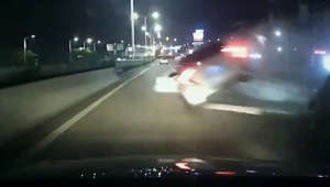 Speeding car nearly causes serious collision when it flips onto two wheels