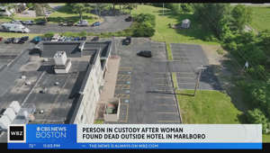 Person in custody after woman found dead in hotel parking lot