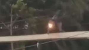 Un motard indonésien en mauvaise posture sur un pont suspendu