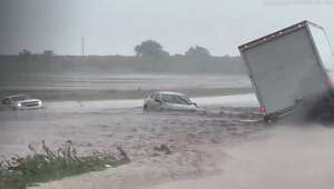 Huge flash flood on Texas highway leaves truck and other vehicles stuck partially submerged in gushing rainwater