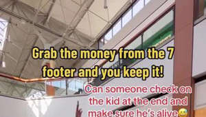 7 foot tall guy holds money in the air and challenges people to try to take it!