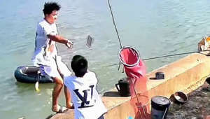 Young man saves his phone before plunging into lake