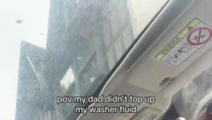 Girl splashes bottled water on her windshield to clean it!