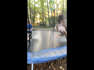 Kid casually plays with a snake on a trampoline