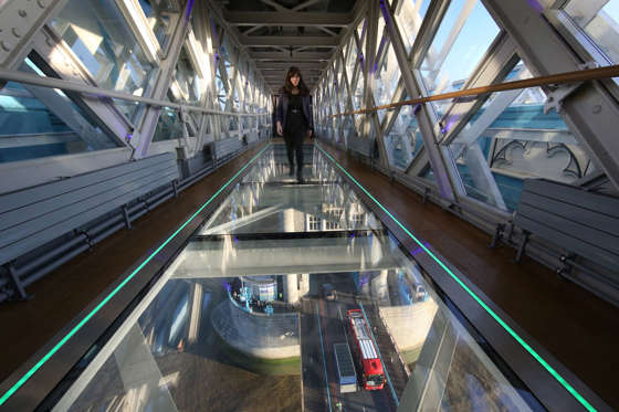 A visitor crosses Tower Bridge's new glass walkway on November 10, 2014 in London, England. The glass floor panels along the bridge's high-level walkways weigh 300 kgs each, cost £1m and will give visitors a new view over the historic bridge crossing The River Thames.