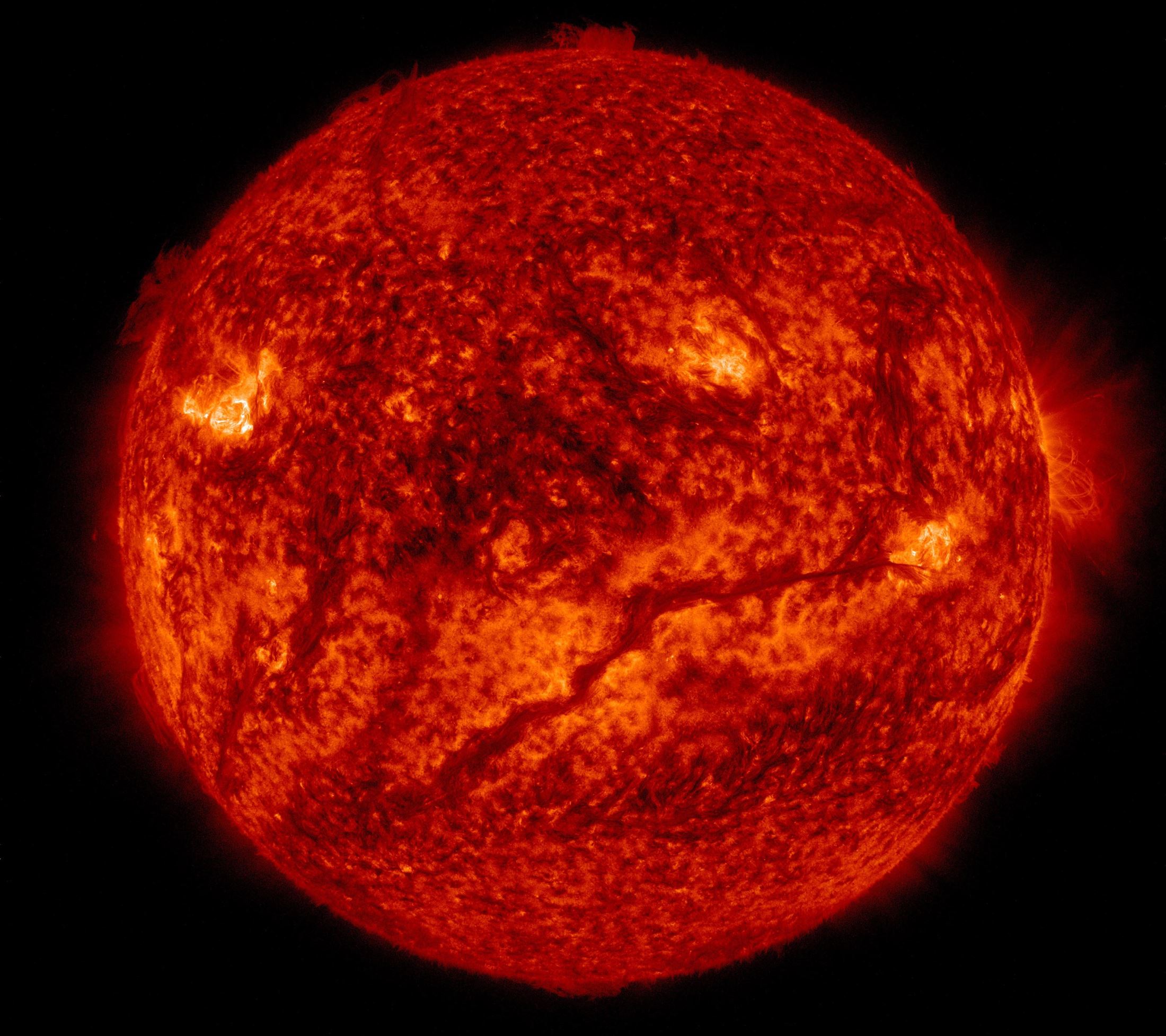 A dark, snaking line across the lower half of the sun from NASA's Solar Dynamics Observatory shows a filament of solar material hovering above the sun's surface. SDO shows colder material as dark and hotter material as light, so the line is, in fact, an enormous swatch of colder material hovering in the sun's atmosphere, the corona. Stretched out, that line – or solar filament as scientists call it – would be more than 533,000 miles long. That is longer than 67 Earths lined up in a row. Filaments can float sedately for days before disappearing. Sometimes they also erupt out into space, releasing solar material in a shower that either rains back down or escapes out into space, becoming a moving cloud known as a coronal mass ejection, or CME. SDO captured images of the filament in numerous wavelengths, each of which helps highlight material of different temperatures on the sun. By looking at such features in different wavelengths and temperatures, scientists learn more about what causes these structures, as well as what catalyzes their occasional eruptions.