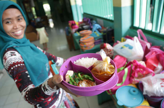 Folie 12 von 20: Sri, a house maid, shows a lunch box she prepared for her employer's child, at an elementary school in Jakarta, Indonesia, Tuesday, May 6, 2014. The lunch consists of rice, meatball soup, and tofu and vegetables. Most countries put a premium on feeding school children a healthy meal at lunchtime. The new American standards for school lunches are giving kids in the United States a taste of the good life already experienced by school children around the world. (AP Photo/Achmad Ibrahim)