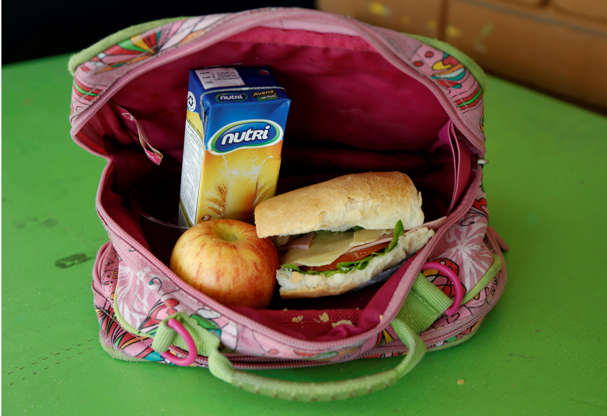Folie 10 von 20: A student's lunch box brought from home sits on display at an elementary school in Quito, Ecuador, Tuesday, May 6, 2014. The lunch consists of a sandwich of ham, cheese, tomato and lettuce, a boxed oatmeal drink, and an apple. (AP Photo/Dolores Ochoa)