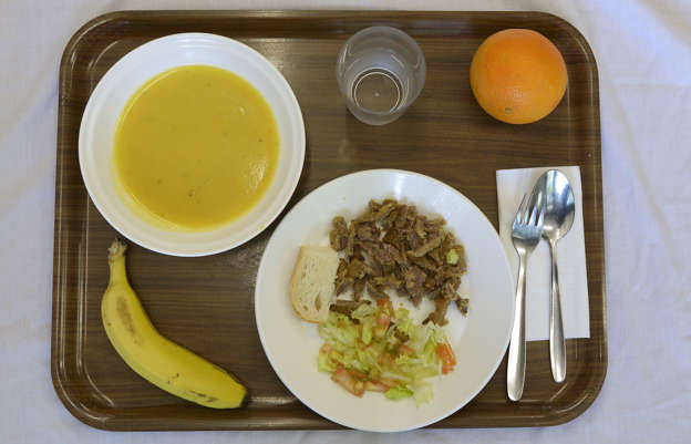 Folie 5 von 20: A school lunch at El Caminet del Besos kindergarten is pictured in Barcelona, Spain, Tuesday, May 6, 2014. The lunch is composed of cream of vegetable soup, pan-fried breast of veal with salad, a piece of bread, an orange or banana and water. Most countries seem to put a premium on feeding school children a healthy meal at lunchtime. U.S. first lady Michelle Obama is on a mission to make American school lunches healthier too. (AP Photo/Manu Fernandez)