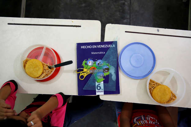 Folie 17 von 20: A math book that reads "Made in Venezuela" is seen next to meal boxes during lunch break at an improvised classroom in a communal house, which is part of state school Monsenor Marco Tulio Ramirez Roa, in La Fria, Venezuela June 2, 2016. REUTERS/Carlos Garcia Rawlins SEARCH "VENEZUELA SCHOOL" FOR THIS STORY. SEARCH "THE WIDER IMAGE" FOR ALL STORIES