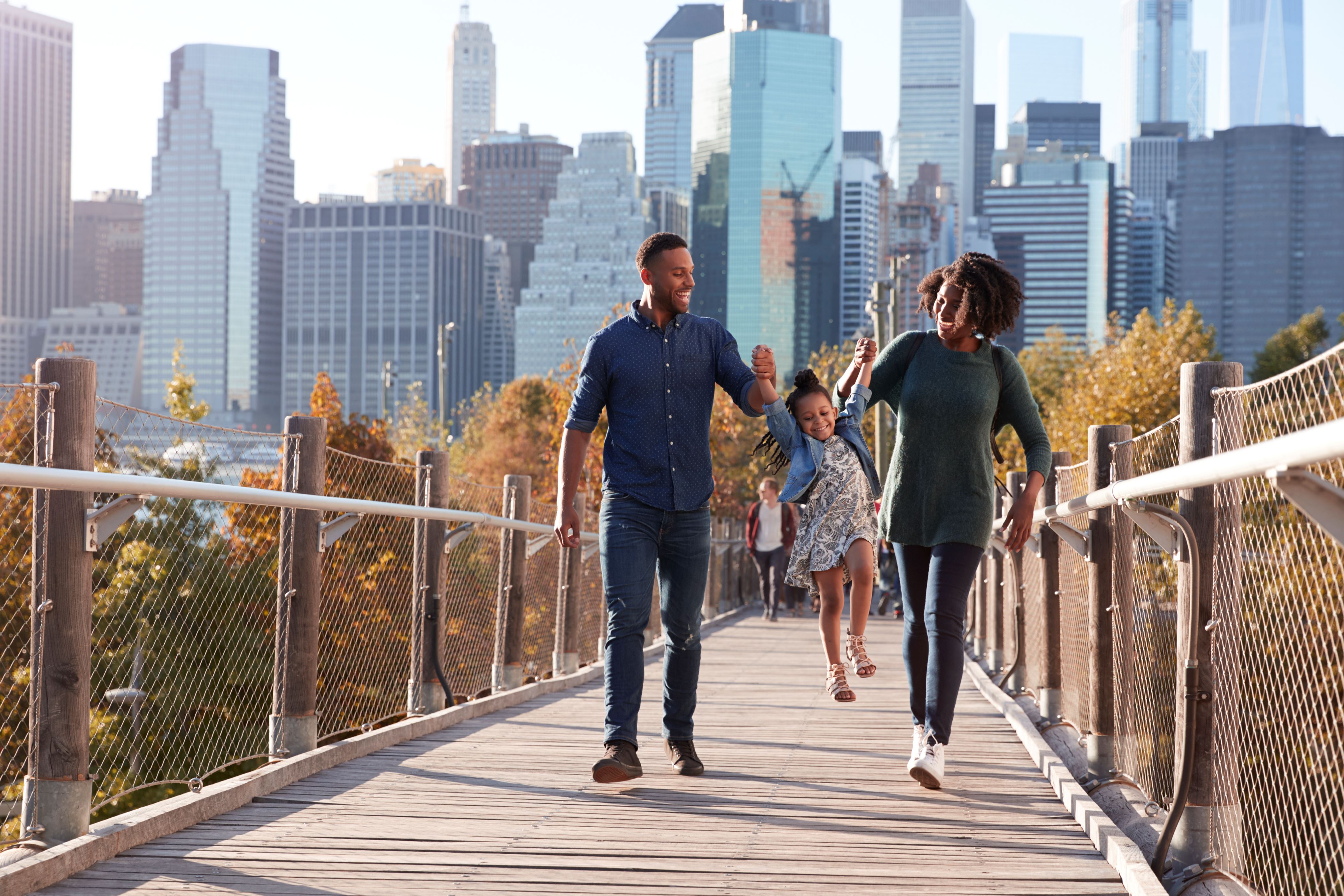 Family with daughter taking a walk on footbridge