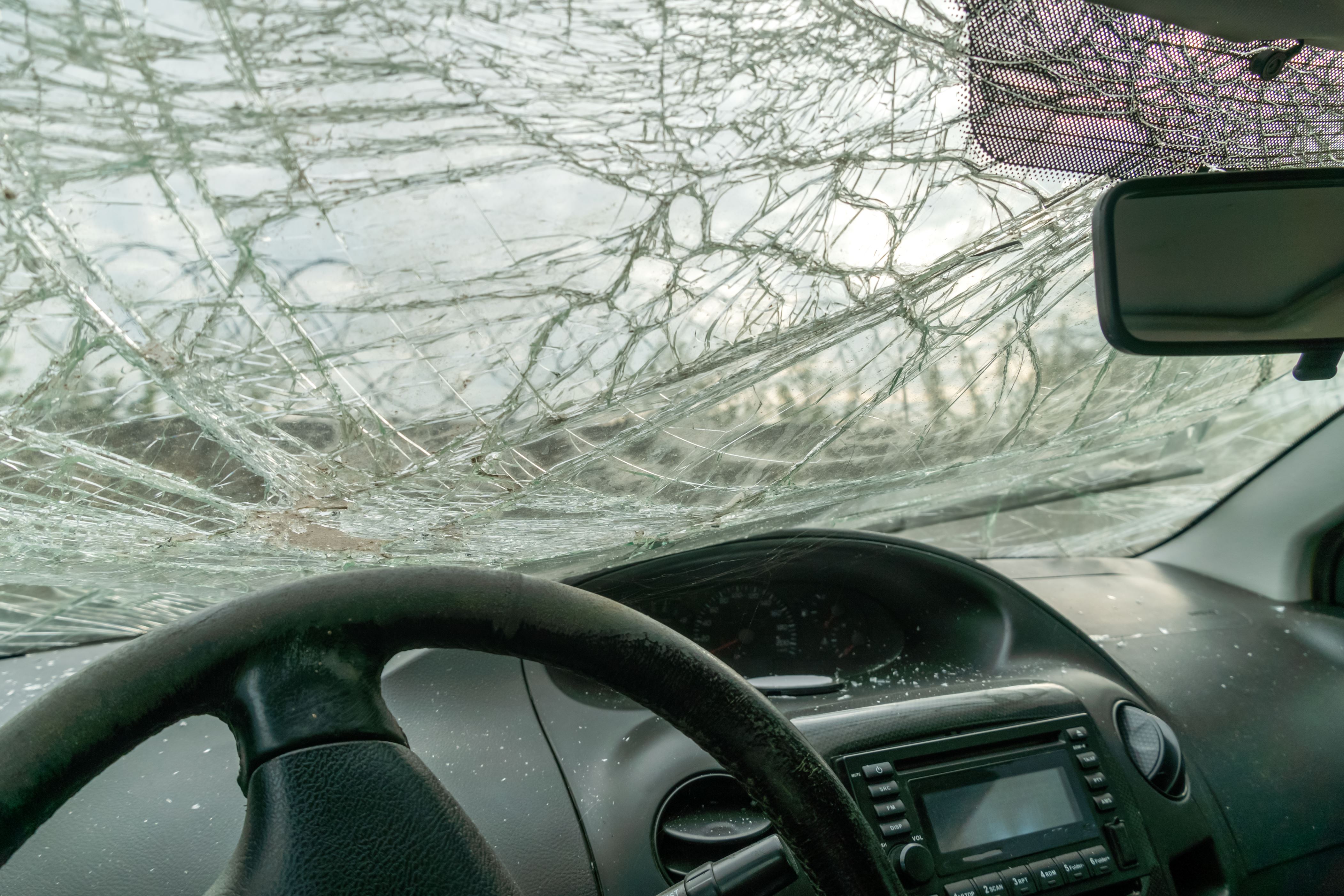 Inside the car, which was damaged as a result of a serious accident, the windshield in the cracks
