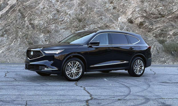a car parked on the side of a road: This handsome devil is the 2022 Acura MDX.
