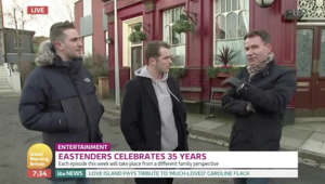 Richard Arnold in a suit standing in front of a store: GMB: EastEnders stars Tony Clay and Max Bowden on storyline