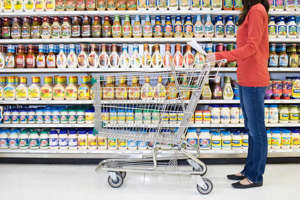A woman walks down an aisle in a supermarket