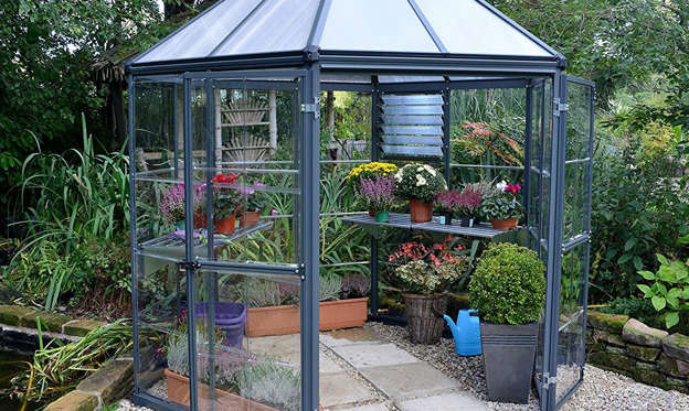 Slide 1 of 7:  This greenhouse hideaway resembles a mini house. It features a heavy-duty, powder-coated and rust-resistant aluminum frame, a galvanized steel base, an integrated gutter system for effective water drainage and collection, and a wide double-hinged door with a lockable door handle. Plus it can be used all year long! Shop Now 
