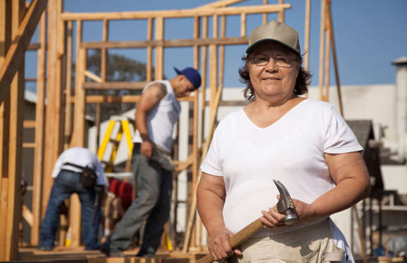 Woman holding hammer at construction site.