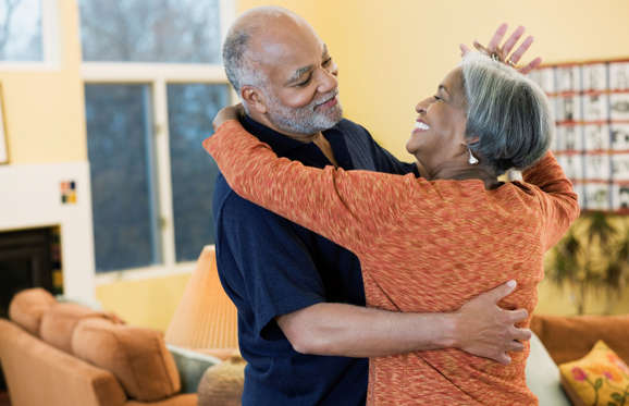 Couple dancing in their home.