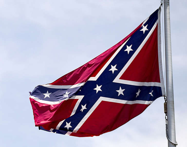 In this June 30, 2015 file photo, a Confederate flag flies at the base of Stone Mountain in Stone Mountain, Ga. Mainstream country music has been quietly distancing itself from the Confederate flag for years, but as the debate reignites following a massacre at a black church in South Carolina on June 17, country artists still struggle to articulate their feelings about the flag’s history and symbolism.