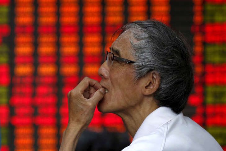 An investor watches an electronic stock market display in Shanghai, China, July 10, 2015.