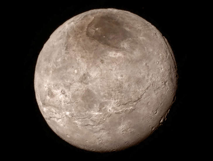 Remarkable new details of Pluto’s largest moon Charon are revealed in this image from New Horizons’ Long Range Reconnaissance Imager (LORRI), taken late on July 13, 2015 from a distance of 289,000 miles  (466,000 kilometers).  A swath of cliffs and troughs stretches about 600 miles (1,000 kilometers) from left to right, suggesting widespread fracturing of Charon’s crust, likely a result of internal processes. At upper right, along the moon’s curving edge, is a canyon estimated to be 4 to 6 miles (7 to 9 kilometers) deep.