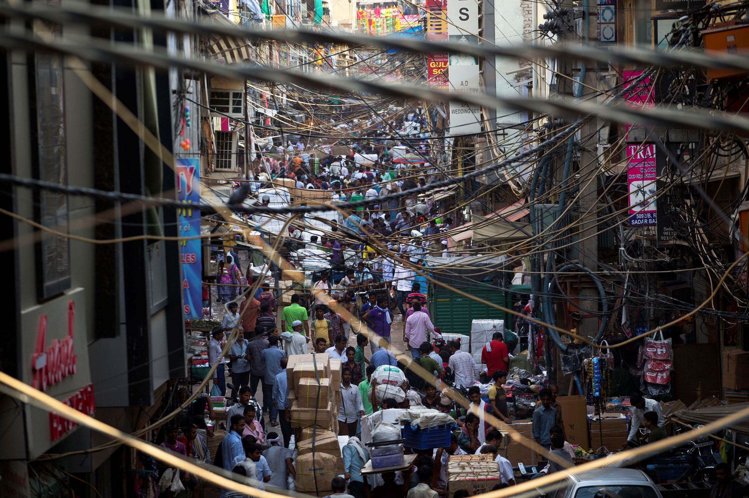 Indians throng a street of a wholesale market on World Population Day in New Delhi, India, Friday, July 11, 2014.
