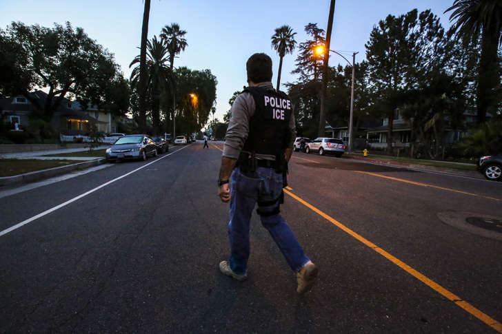 Jorge Field of ICE Enforcement and Removal Operations walks on his way to raid and apprehend an immigrant without legal status who may be deportable on Aug. 12, 2015 in Riverside, Calif. Immigration and Customs Enforcement officials say they are relying more than ever on costly manhunts to locate immigrants in the country illegally who have criminal records. In the past, the agency would simply contact local jails where such immigrants were being detained and ask jail officials to hold them until an ICE van could pick them up, but hundreds of counties across the country stopped honoring such requests after a federal judge last year found that practice unconstitutional.