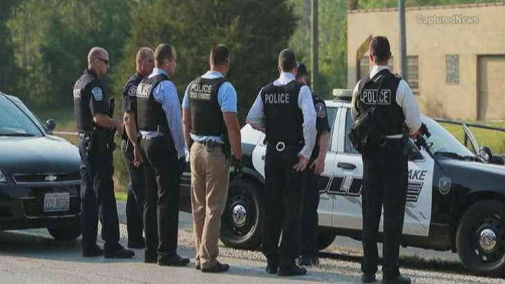 Law enforcement officials at the site where a police officer was fatally shot in Fox Lake, Illinois, September 1, 2015.