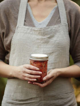 Woman holding jar of fermented sauerkraut vegetables