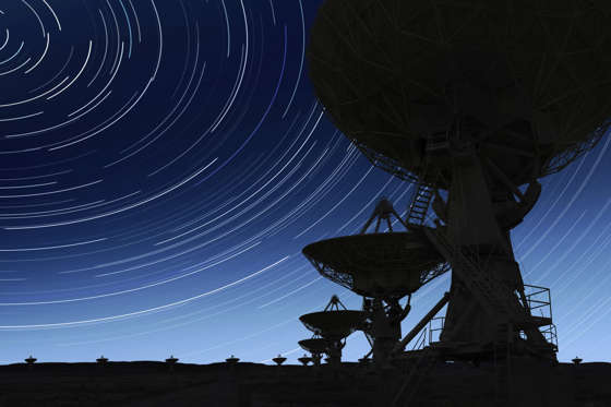 large radio telescopes in silhouette at night with long exposure starry sky (XL)