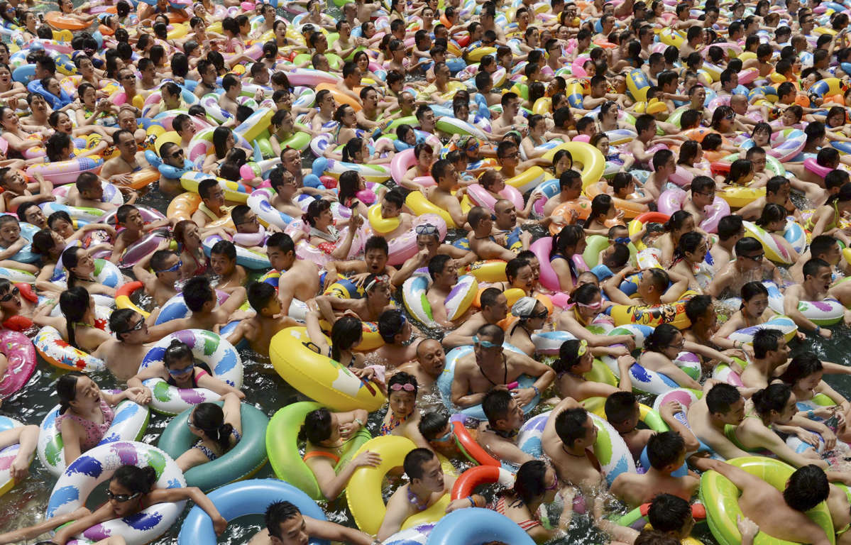Visitors crowd an artificial wave swimming pool at a tourist resort to escape the summer heat in Daying county of Suining, Sichuan province, China, July 11, 2015.