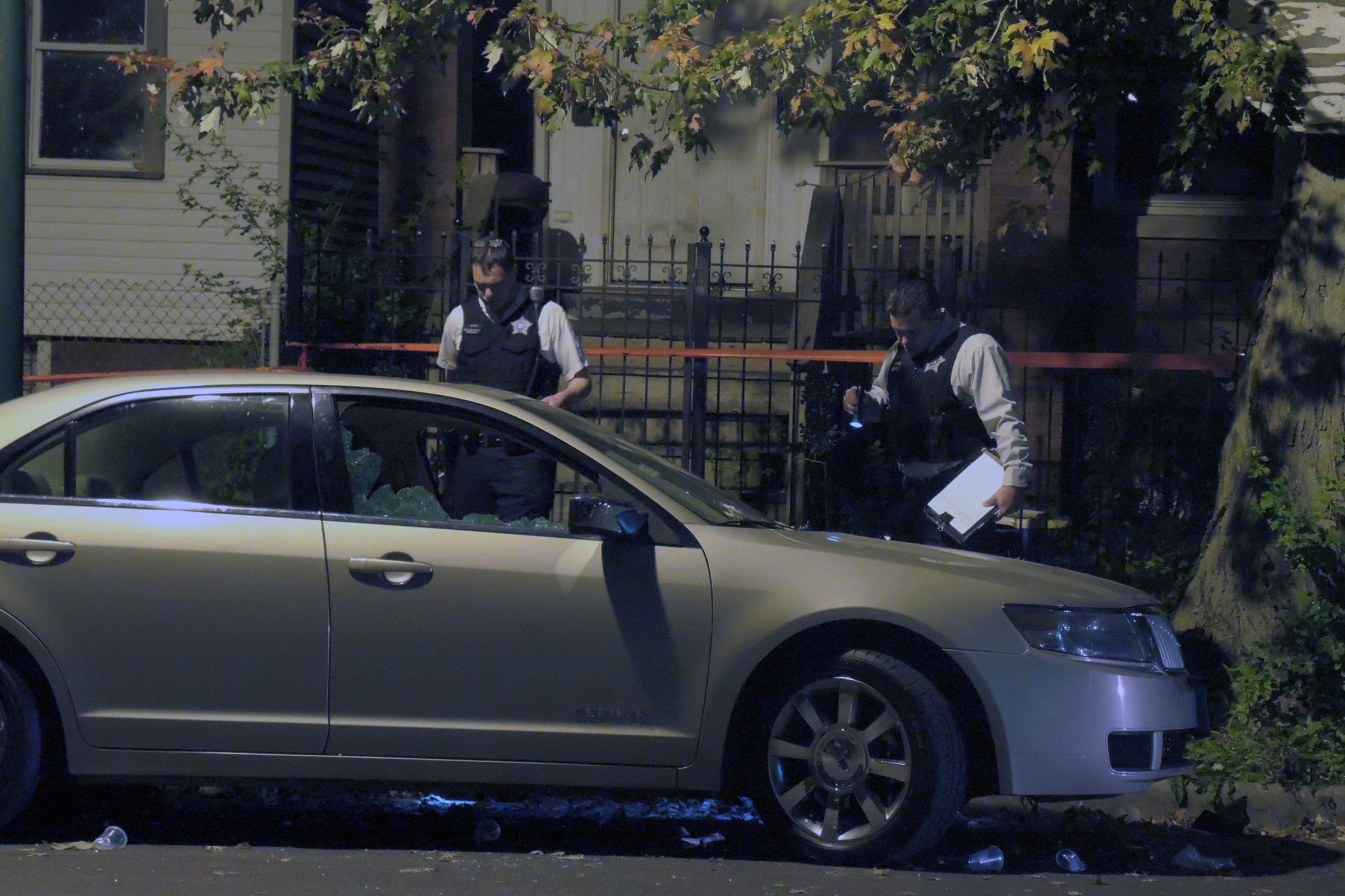 Police officers investigate the scene of the shooting in the 5200 block of South Justine Street where four people were wounded late Sunday evening on Sept. 27, 2015 in Chicago.