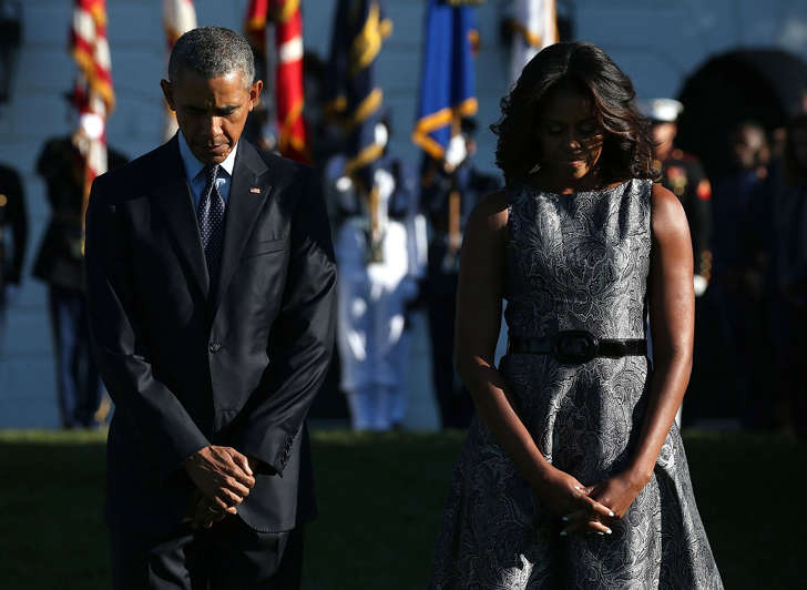 US President Barack Obama and first lady Michelle Obama bow their heads during a moment of silence to mark the 14th anniversary of the 9/11 terror attacks, at the White House on September 11, 2015 in Washington, DC.