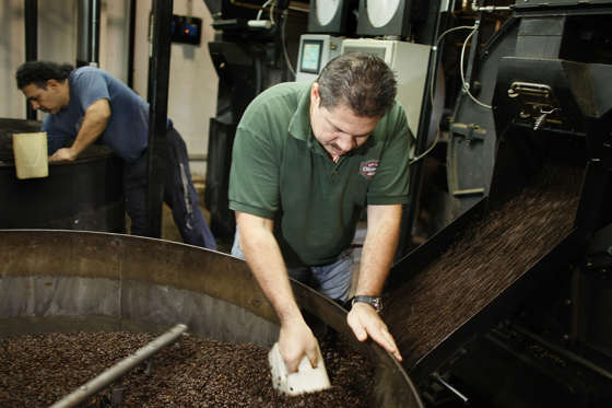MIAMI - MARCH 3: Hernando Vasquez checks beans pouring from the roaster before they are bagged at Colonial Coffee Roasters March 3, 2008 in Miami, Florida. Coffee prices recently hit its highest level in a decade, as continuing weakness in the dollar kept many commodity markets soaring.