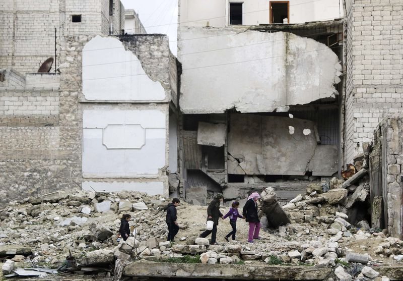 Children walk on the debris of a damaged building at al-Myassar neighborhood of Aleppo. (Thomson Reuters)