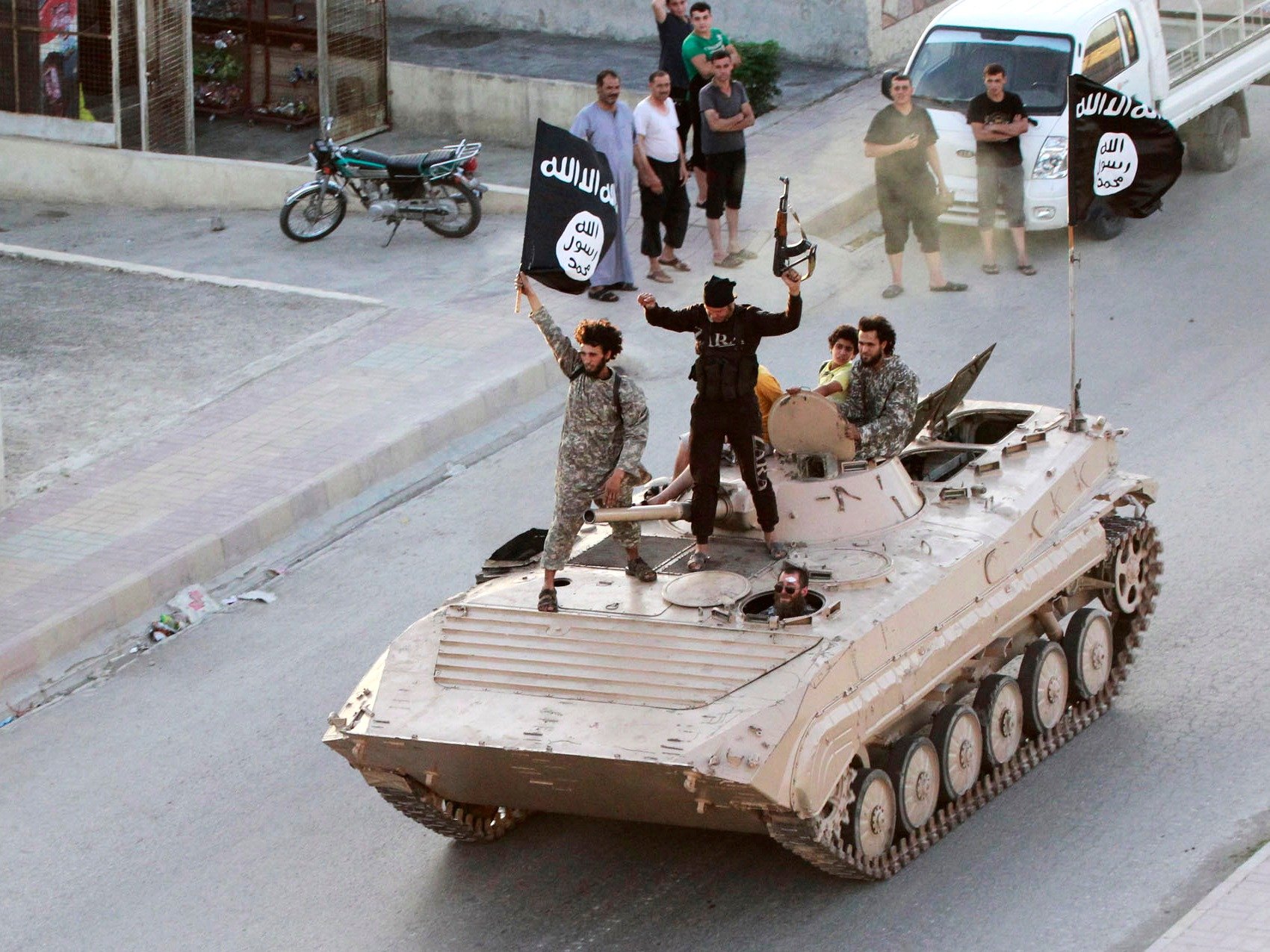 Militant Islamist fighters take part in a military parade along a street in northern Raqqa province on June 30, 2014. (Reuters)
