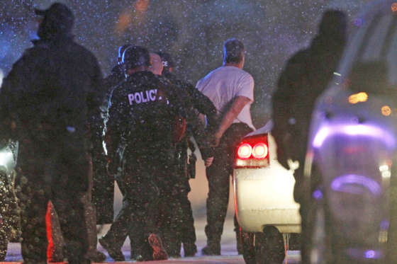 The handcuffed suspected gunman at the Planned Parenthood clinic is moved to a police vehicle in Colorado Springs, Colorado November 27, 2015. Police arrested a gunman who stormed the Planned Parenthood abortion clinic in Colorado Springs on Friday and opened fire with a rifle in a burst of violence that left at least 11 people injured, including five officers, authorities said.