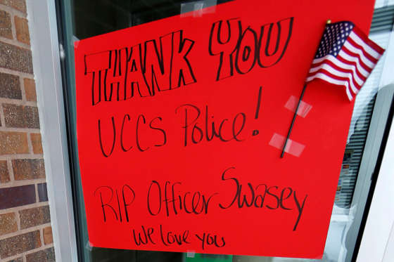 A sign and flowers stand outside the offices of public safety on Nov. 28, 2015, on the campus of the University of Colorado-Colorado Springs to mark the Friday shooting of one of the force's officers at a nearby Planned Parenthood clinic in Colorado Springs, Colo.