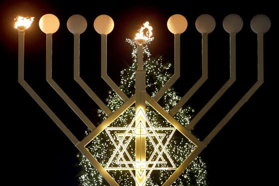 Payment Status: Unpaid  FILE - In this Tuesday, Dec. 16, 2014 file photo, the first flames of a a giant Hanukkah Menorah in front of a Christmas tree at the Brandenburg Gate in Berlin, Germany, burn at the launch of the eight-day Jewish Festival of Lights, named Hanukkah. The lights were inflamed by German Interior Minister Thomas de Maiziere and Rabbi Yehuda Teichtal. (AP Photo/Michael Sohn, File