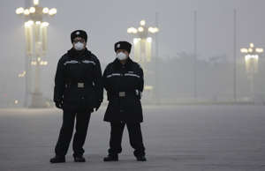 Policemen wear protective masks at the Tiananmen Square on an extremely polluted...