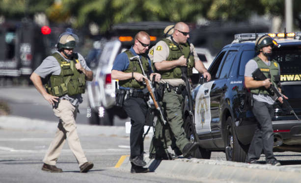 San Bernardino police officers in SWAT gear secure the scene of a mass shooting at the Inland Regional Center in San Bernardino, Calif., on Wednesday, Dec. 2, 2015.