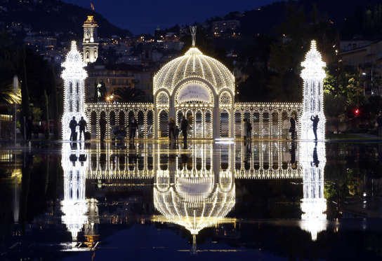 People take pictures in front of a Christmas light installation in Nice, southeastern France, on December 16, 2014. AFP PHOTO / VALERY HACHE (Photo credit should read VALERY HACHE/AFP/Getty Images)