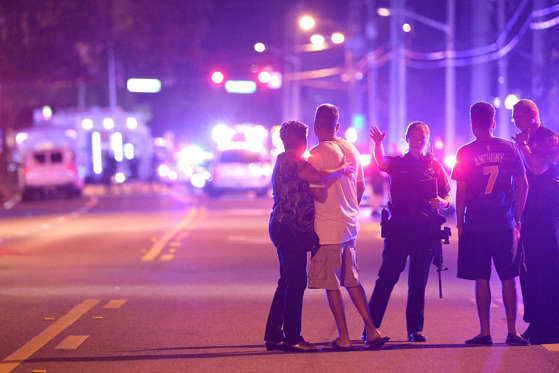Orlando Police officers direct family members away from a fatal shooting at Pulse Orlando nightclub in Orlando, Fla.